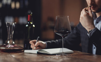 Winemaker sommelier man sniffing aroma red wine in glass - obrazy, fototapety, plakaty
