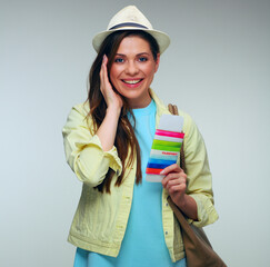 Smiling woman with handbag wearing blue dress and holding passport.