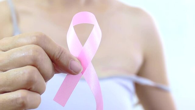 Pink ribbon with a breast cancer woman - A breast cancer survivor woman making a pink ribbon. Breast cancer surgery scars by partial mastectomy. Cancer awareness concept.
