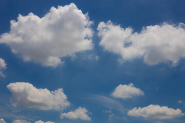 Blue skies with heavy amount of white fluffy clouds.