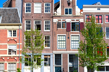 Fototapeta na wymiar Old vintage colorful houses in Amsterdam, Netherlands with trees