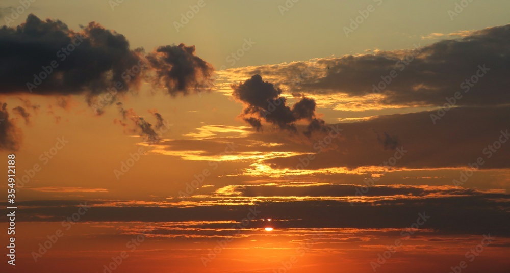 Wall mural Beautiful orange sunset with brown clouds over the city, natural background