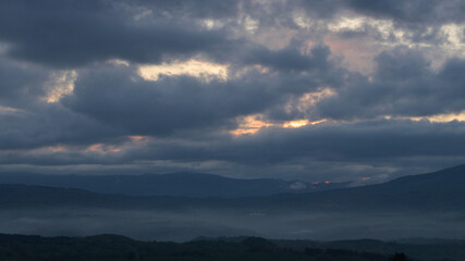 薄暗い夕日の雲と山並み