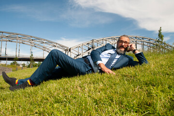 Naklejka na ściany i meble lazy businessman in blue suit on grass