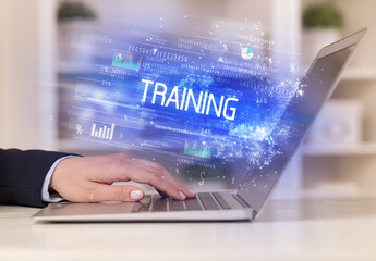 Closeup of businessman hands working on laptop with TRAINING inscription, succesfull business concept