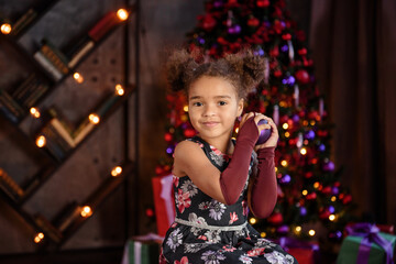 Fototapeta na wymiar Merry Christmas! Cute little child girl is decorating the Christmas tree.
