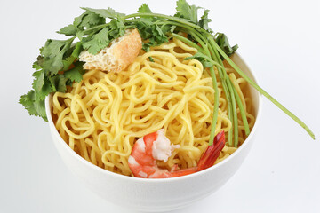 Fresh yellow egg noodle prawn tofu coriander leaf in bowl on whit background