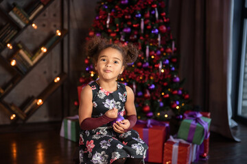 Fototapeta na wymiar happy little child with gifts and Christmas tree and lights.