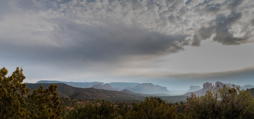 Fototapeta na wymiar Dramatic clouds form over mist shrouded mountains