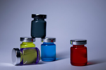 Little bottles with multicoloured liquid on white-gray background. Isolated. Board games. Cure - medicine, vaccine. Coronavirus or covid-19 - pandemic. High quality photo
