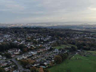 Obraz premium aerial drone view of housing on the edge of fields with forest and harbour in the distance