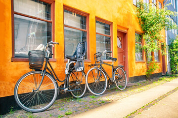 Fototapeta na wymiar Old yellow house of Nyboder district with bicycles. Old Medieval district in Copenhagen, Denmark. Summer sunny day