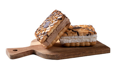 Two biscuits spread on top of chocolatiers with layers of chocolate and milk cream lying on a wooden plank isolated on white background.