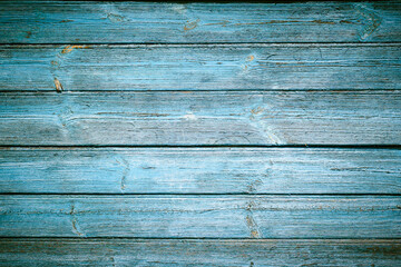 Texture of old painted wood in blue with darkening at the corners.