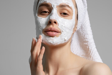 Woman in towel with  white  mask on face closeup portrait. 