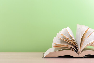 The book is open, lying on the table, sheets fanned out on a green background.