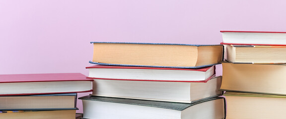 Stacks of books several on a pink background close-up. Back to school, education, learning,