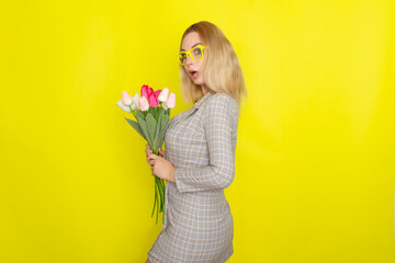 Blonde woman in plaid dress holding tulips bouquet