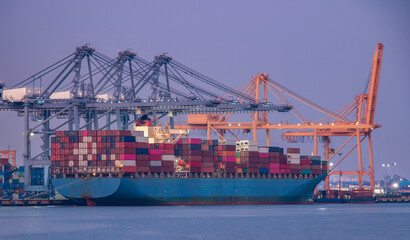 Naklejka premium Logistics and container loading by large barges by sea in a harbor full of containers waiting to be transported