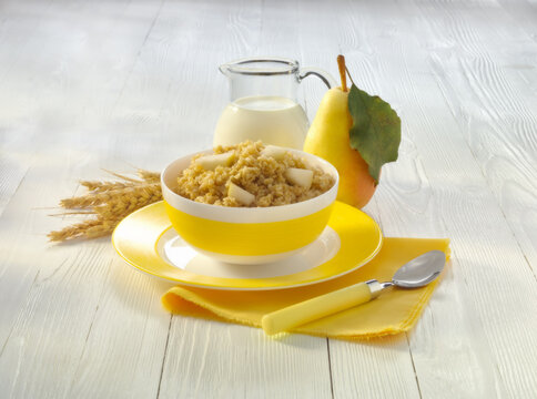 A Bowl Of Millet Porridge With A Pear On The Table