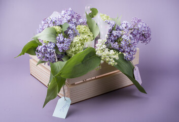 sale of lilac bouquets in a wooden box. Bouquet on a blue background.