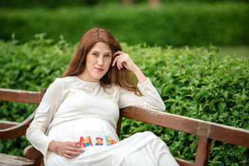 Pregnant woman holding a letter from plastic.