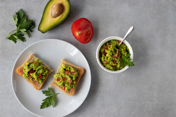 Avocado and chili pepper appetizer on square toasts in a white plate. Top view.