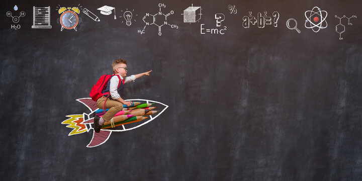 Back to school. Boy flying on rocket from colorful pencils and pointing up. 
