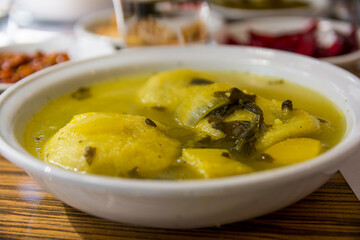 Traditional hot yellow Kubbe soup, a famous middle eastern dumplings soup dish, served in a bowl. Jerusalem, Israel. 
