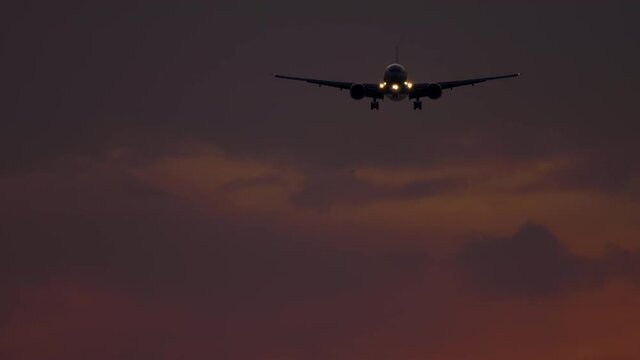 Airplane approaching over ocean at sunset backgfround