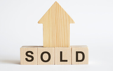 Wooden blocks with the word SOLD , house. The concept of the high cost of rent for an apartment or home. Interest rates are rising. Real estate market.