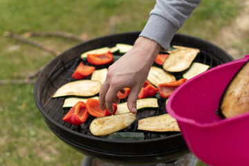 Grilled Vegetables (red pepper, zucchini, eggplant). ook prepares vegetables on the grill
