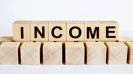 INCOME word from wooden blocks on desk, search engine optimization concept