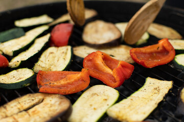 Grilled Vegetables (red pepper, zucchini, eggplant). ook prepares vegetables on the grill