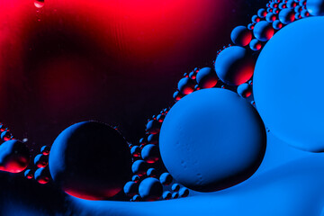 Macro shot of oil bubbles with water on colorful background. Space and universe planets styled...