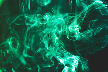 Green abstract shaped smoke against black background.