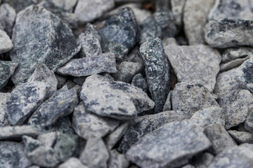 Small stones of raw marble on a walkway in a park. Natural texture in natural light.