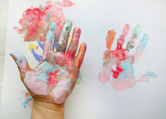 the imprint of a human hand with colorful paint and paint on the hand
