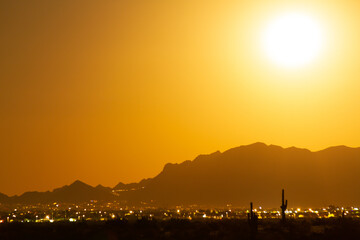 Long exposure of the full moon rising on the desert and city of Phoenix