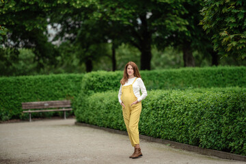 Beautiful pregnant girl walking in the Park.