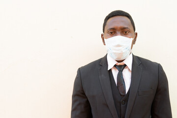 Portrait of African businessman with mask against white background