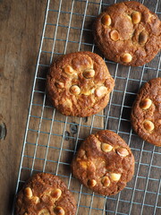 White chocolate and macadamia cookies on wooden background