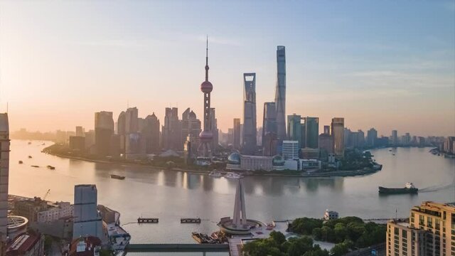 Time-lapse or Hyper-lapse Aerial View of Oriental Pearl Tower Financial District Pudong. Rising Up Shanghai Tower on the Bund Huangpu River. Ships Sail Around Downtown City Center above Waitan Puxi.