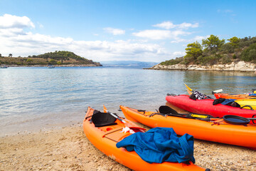 Kayaks arranged on the beach in Greece in hot summer day. Best hobby for the summer vacation