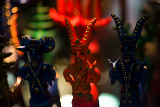Beautiful vintage colourful wooden satanic dolls at market. Baphomet dolls is folks cultural symbol of Satanic cult. With selective focus on one doll.
