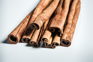 closeup large group of dry cinnamon sticks served on white table surface