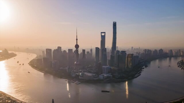 Time-lapse or Hyper-lapse Aerial View of Oriental Pearl Tower Financial District Pudong on Early Morning. Shanghai Tower on the Bund Huangpu River. Ships Sail Around Downtown City Center Waitan Puxi.