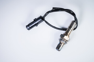 The oxygen sensor is a new lambda sensor. Spare parts on the car on a gray gradient background