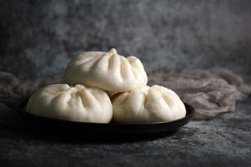Fototapeta na wymiar Steamed BBQ pork bun, also know as Baozo, is a type of filled bun or bread-like dumpling in various Chinese cuisines.
