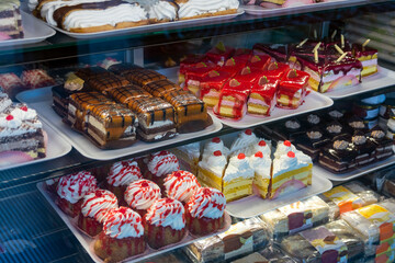 Showcase pastry shop with a delicious, beautiful, attractive cakes with cream.